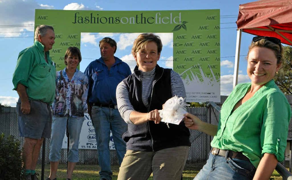 Sandy and Sally Smith and Jamie Macdonald watch as Warwick Picnic Races Club president Helen Lewis and Tina Macdonald battle it out for the fascinator that will be auctioned off as part of the silent auction today.